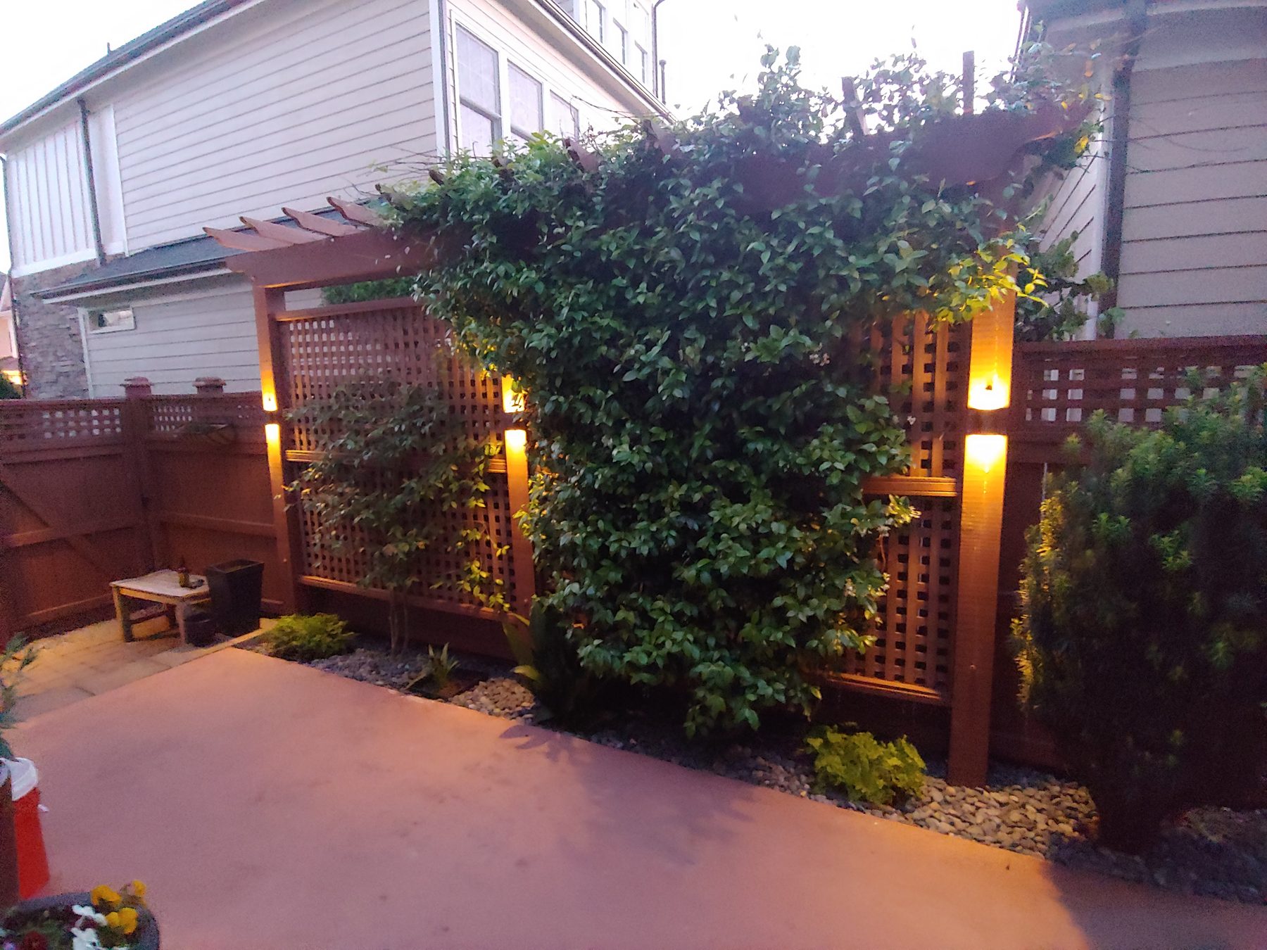 Landscape lighting illuminating a garden pergola at dusk