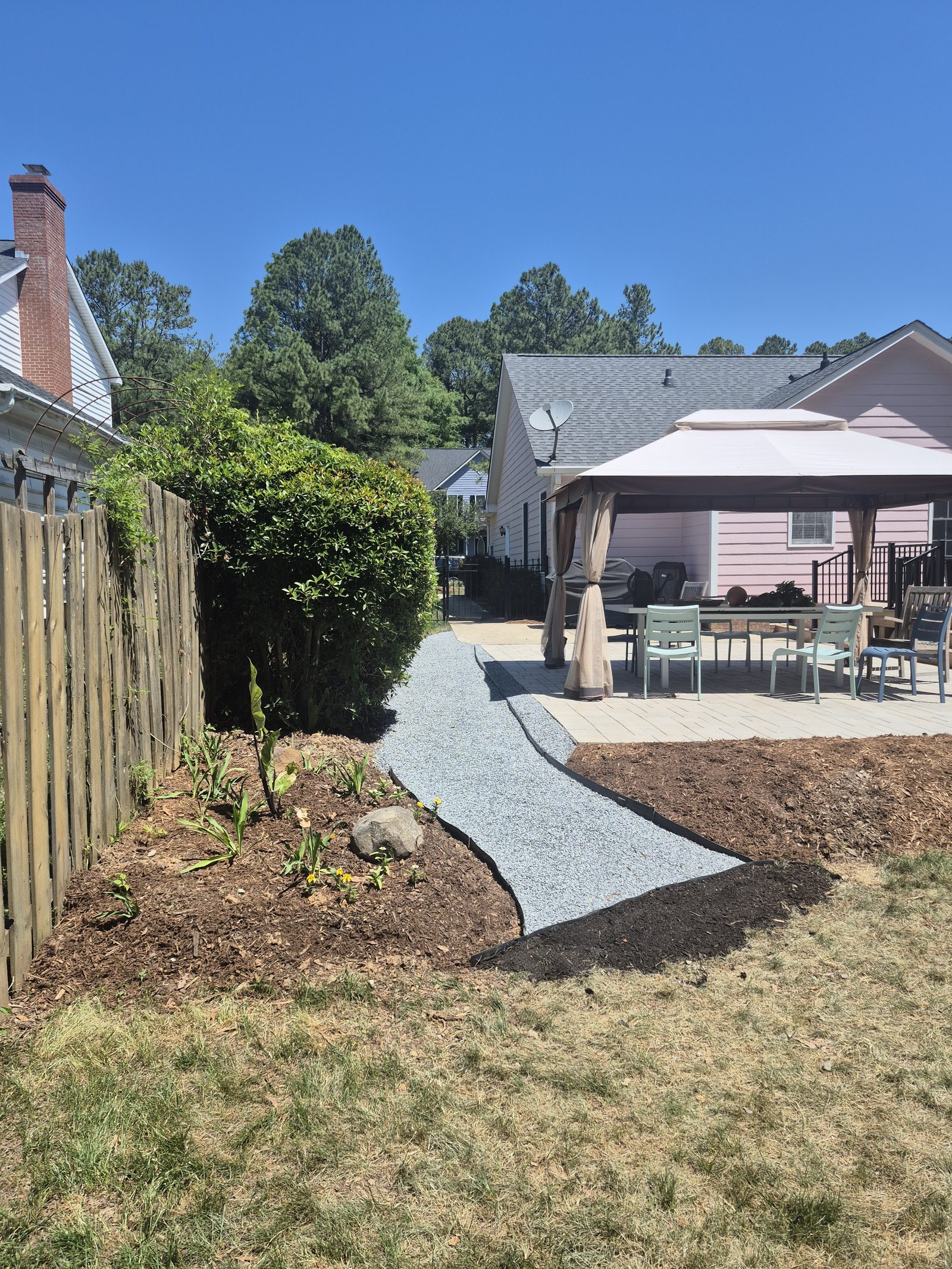 Side yard after gravel path installation, clean gravel walkway