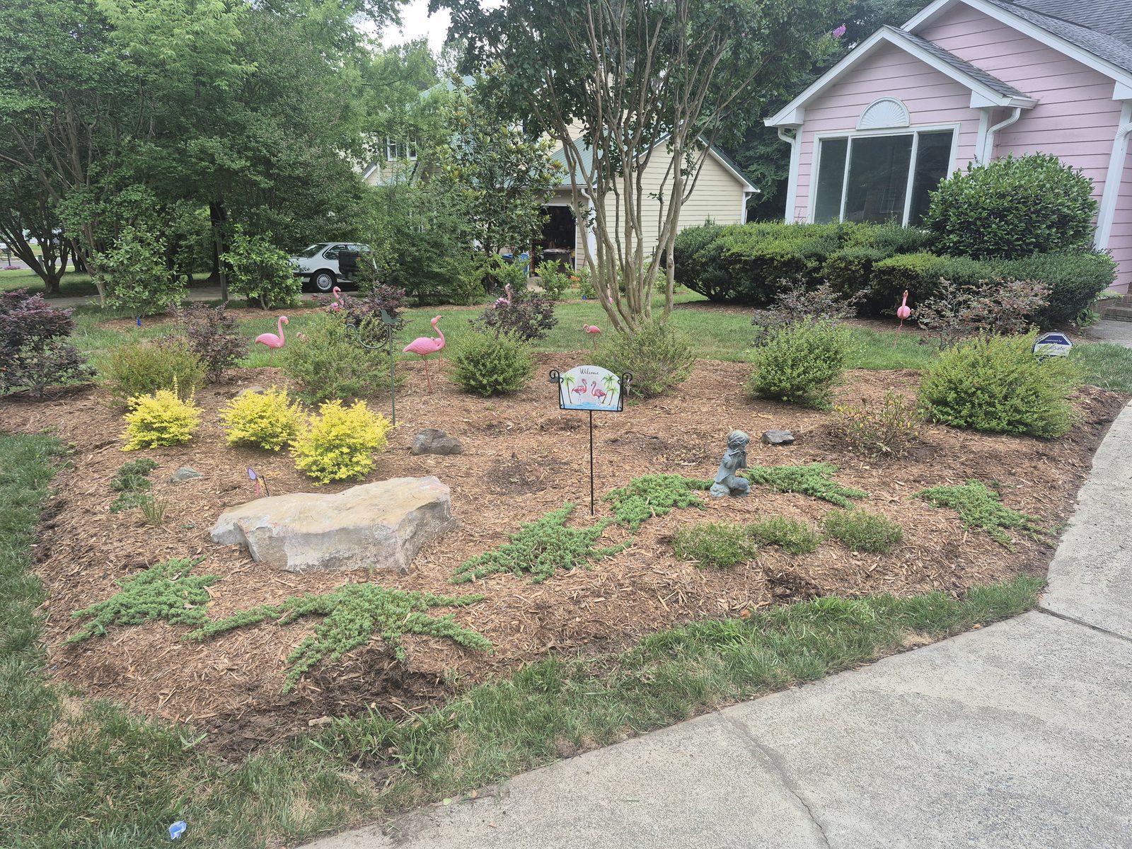 Completed foundation planting installation with layered mulched beds